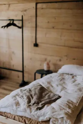 a bed in a room with a wooden wall at 4 bedroom house for 8 guests in Brülisau