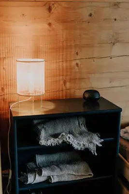 a table with a lamp on top of it at Zimmer Fählensee im Appenzeller Ferienhaus in Brülisau