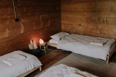 a room with two beds in a wooden cabin at Zimmer Fählensee im Appenzeller Ferienhaus in Brülisau