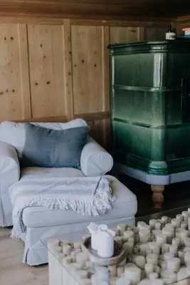 a living room with a couch and a green fireplace at Zimmer Alpstein im Appenzeller Ferienhaus in Brülisau
