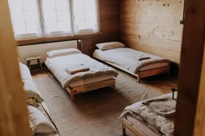 a room with two beds and two windows at Zimmer Appenzell im Appenzeller Ferienhaus in Brülisau