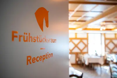a sign for a restaurant on a wall in a room at Hotel Garni Rössli in St. Gallen