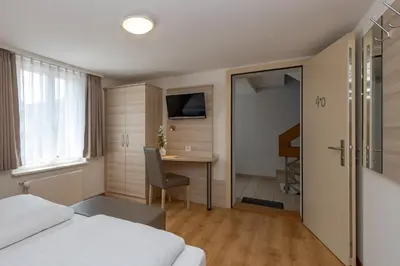 a hotel room with a bed and a table and a desk at Hotel Garni Rössli in St. Gallen