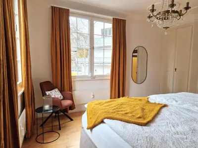a bedroom with a bed and a chair and a window at FEWOCASA Central Family Apartment Rorschach - Lake Constance - 15 min OLMA in Rorschach