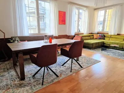 a living room with a wooden table and chairs at FEWOCASA Central Family Apartment Rorschach - Lake Constance - 15 min OLMA in Rorschach