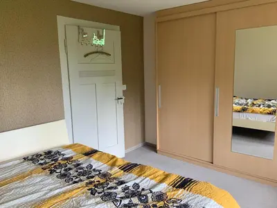 a bedroom with a bed and a closet and a door at Appenzellerland Schöne Wohnung in einem Wandergebiet in Teufen