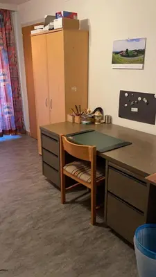 a room with a desk with a chair and a table at Appenzellerland Schöne Wohnung in einem Wandergebiet in Teufen