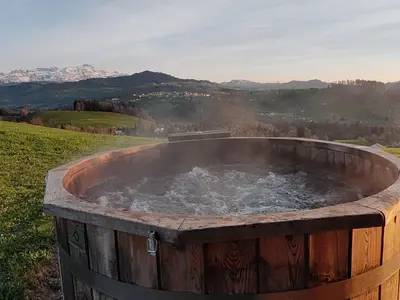 a wooden tub filled with water in a field at Apartment sunehus-ch by Interhome in Stein