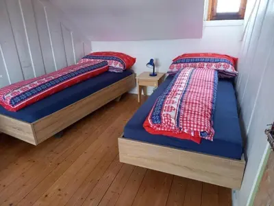 two twin beds in a room with wood floors at Holiday Home Ferienhaus- - Stöckli Klingenbuch 20 by Interhome in Rehetobel