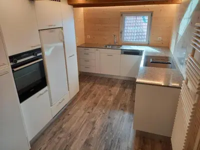 a kitchen with white appliances and a wooden floor at Holiday Home Ferienhaus- - Stöckli Klingenbuch 20 by Interhome in Rehetobel