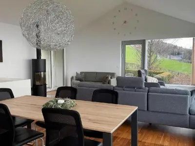a living room with a table and a couch at Holiday Home Unterbilchen by Interhome in Eggersriet