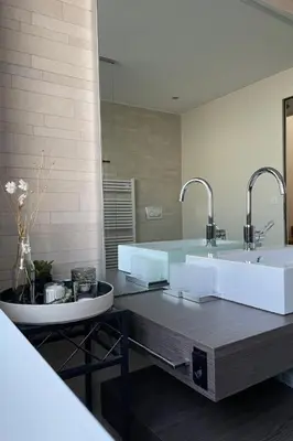 a bathroom with two sinks and a large mirror at Holiday Home Unterbilchen by Interhome in Eggersriet
