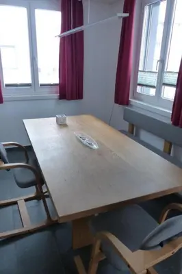 a wooden table and chairs in a room with windows at Apartment Moderne FeWo by Interhome in Appenzell