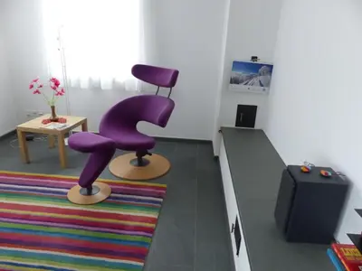 a living room with a purple chair and a rug at Apartment Moderne FeWo by Interhome in Appenzell