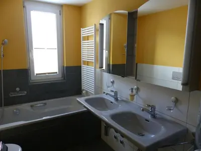 a bathroom with a sink and a tub and a mirror at Apartment Moderne FeWo by Interhome in Appenzell