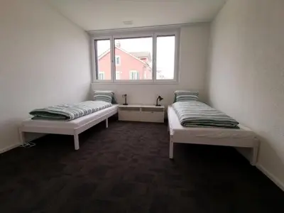 two beds in a room with a window at Apartment HIRSCHEN by Interhome in Gossau