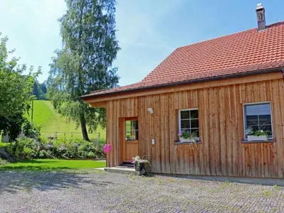 a wooden house with a garden in front of it at Apartment Vordere Au by Interhome in Schwellbrunn