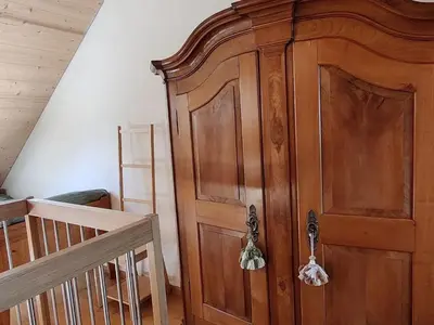 a wooden cabinet in a room with a crib at Apartment Bauernhaus VordereAu by Interhome in Schwellbrunn