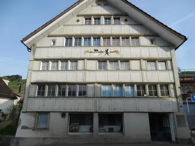 a building with a clock on the side of it at Apartment Alpen-Paradies Edelweiss Urnäsch by Interhome in Urnäsch