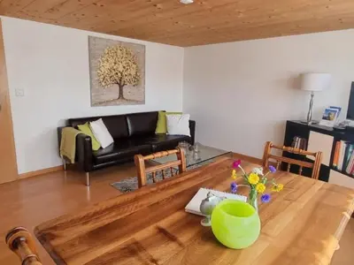 a living room with a table and a couch at Apartment Tiererlebnishof Windegg by Interhome in Urnäsch