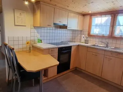 a kitchen with wooden cabinets and a wooden table and a sink at Apartment Tiererlebnishof Windegg by Interhome in Urnäsch