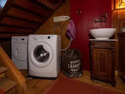 a bathroom with a washing machine and a sink at Holiday Home Lindeli by Interhome in Sankt Peterzell