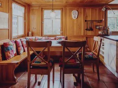 a kitchen with a table and chairs and a couch at Holiday Home Lindeli by Interhome in Sankt Peterzell