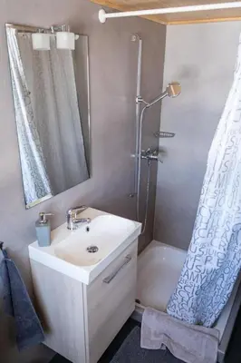 a bathroom with a sink and a shower with a mirror at Holiday Home Hörli by Interhome in Sankt Peterzell