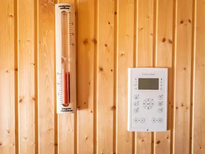 a remote control and a thermometer on a wooden wall at Holiday Home Hörli by Interhome in Sankt Peterzell