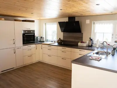 a kitchen with white cabinets and a wooden ceiling at Holiday Home Hörli by Interhome in Sankt Peterzell