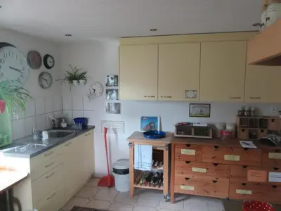a kitchen with yellow cabinets and a sink and a counter at Holiday Home Haus Chrumis by Interhome in Sankt Peterzell