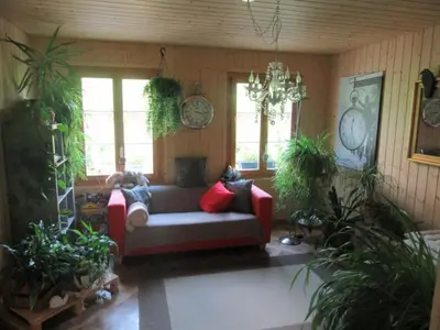 a living room with a couch and potted plants at Holiday Home Haus Chrumis by Interhome in Sankt Peterzell