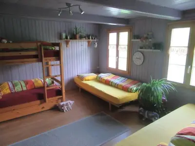 a room with two bunk beds and a couch at Holiday Home Haus Chrumis by Interhome in Sankt Peterzell