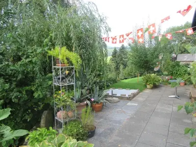 a garden with potted plants on a patio at Holiday Home Haus Chrumis by Interhome in Sankt Peterzell