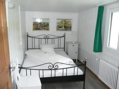 a bedroom with a black and white bed and a window at Holiday Home Frohheim by Interhome in Sankt Peterzell