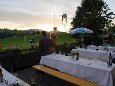 a man and woman standing in front of tables with wine glasses at Holiday Home Frohheim by Interhome in Sankt Peterzell