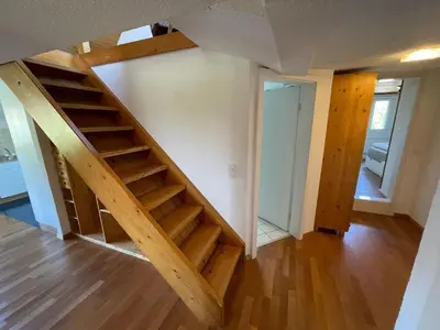 a wooden staircase in a room with a living room at Apartment Wartheim by Interhome in Heiden