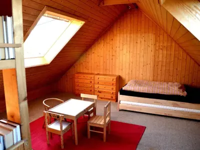 a bedroom with a bed and a table in a attic at Holiday Home See in Sicht by Interhome in Wolfhalden