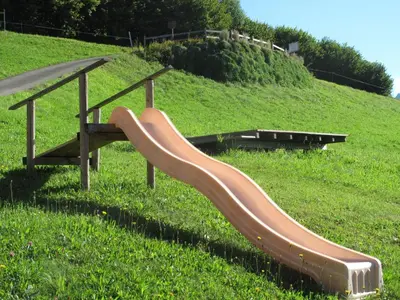 a slide in a grassy field with a hill at Apartment Gubel by Interhome in Alt Sankt Johann