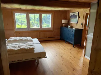 a bedroom with a bed and a dresser and windows at Holiday Home Bijou in Unterwasser by Interhome in Unterwasser