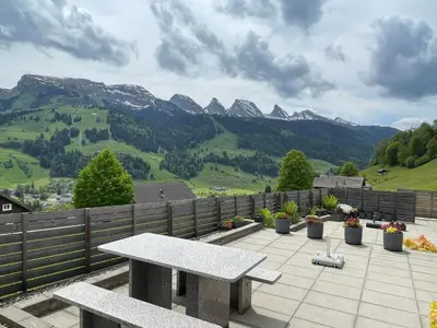 a picnic table on a patio with mountains in the background at Holiday Home Bijou in Unterwasser by Interhome in Unterwasser