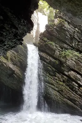 a waterfall on the side of a rock wall at Apartment Bergsicht by Interhome in Wildhaus