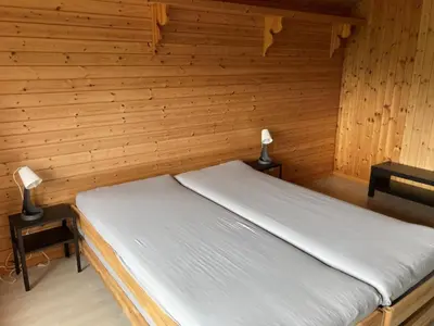 a bed in a wooden room with two lamps at Apartment Sweet Home by Interhome in Wildhaus