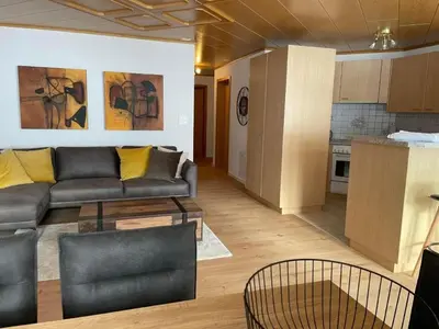 a living room with a couch and a kitchen at Apartment Friedegg by Interhome in Wildhaus