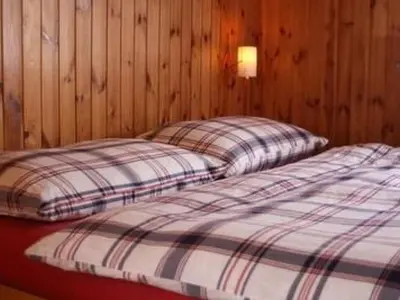 two beds in a room with wooden walls at Holiday Home MECK-HEI by Interhome in Wildhaus
