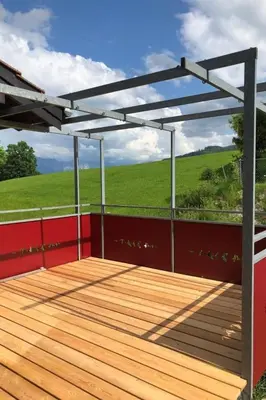 a pergola on a deck with a view of a field at Holiday Home MECK-HEI by Interhome in Wildhaus