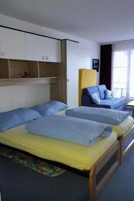 a bedroom with two beds and a couch at Apartment Studio Friedegg by Interhome in Wildhaus