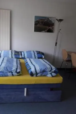 a bed with blue and white pillows in a room at Apartment Studio Friedegg by Interhome in Wildhaus