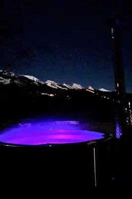 a hot tub lit up in purple at night at Holiday Home Chalet Chic-Hot Pot by Interhome in Wildhaus