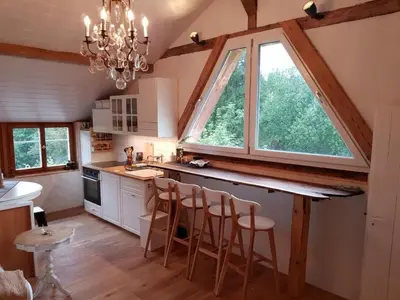 a kitchen with a counter and a large window at Apartment Studio Chic mit Whirlpool by Interhome in Wildhaus